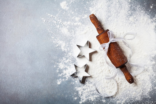 Bakery background for cooking christmas baking with rolling pin and scattered flour on kitchen table top view.