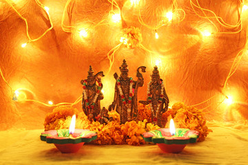 hindu god ram, sita, laxman, hanumaan statue with decorative lights, oil clay lamps and flowers for diwali celebration - obrazy, fototapety, plakaty
