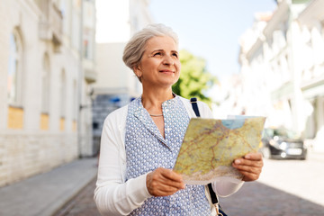travel, tourism and retirement concept - senior woman or tourist with map on city street - obrazy, fototapety, plakaty