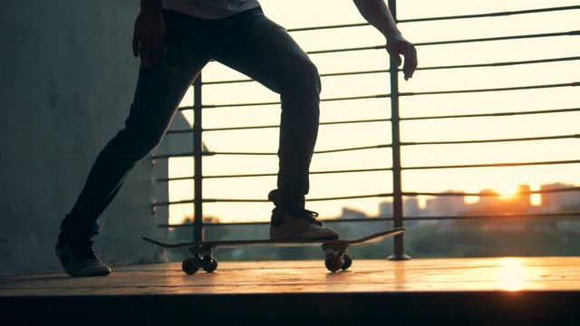 Man starts to ride his skateboard, slow motion.