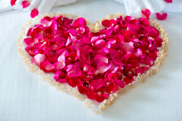 Honeymoon suite, Wedding bed topped with rose petals set to heart from for valentine.Valentine background.