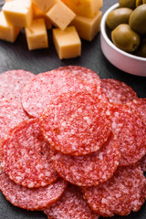 delicious sliced salami on a stone plate wooden background