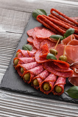 Cold smoked meat plate on a rustic wooden background