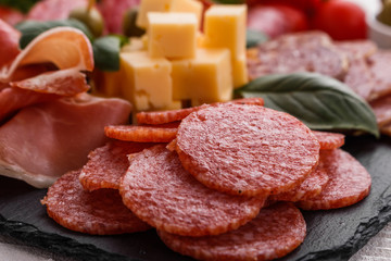 Cold smoked meat plate on a rustic wooden background