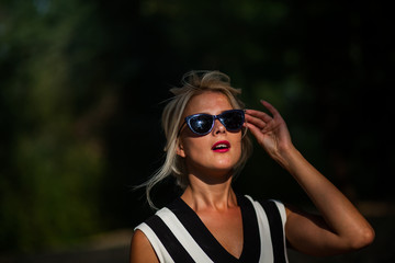 beautiful blonde woman in the autumn forest at sunset