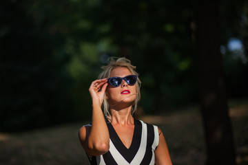 beautiful blonde woman in the autumn forest at sunset