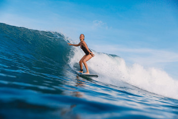 Surfer girl on ocean wave. Woman in ocean during surfing
