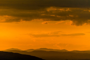 Un tramonto arancione intenso sui monti Martani dopo un temporale