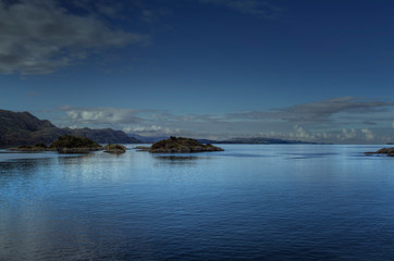 Fototapeta na wymiar View over a Scottish lake with blue reflection