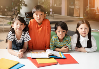 The children opened book,prepare for read together,warm light tone,blurry light design background