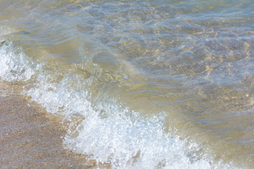 Fototapeta na wymiar natural background. sea wave with foam runs on the sandy shore