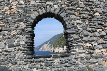 Fototapeta premium Mura in pietra con finestra ad arco sul mare