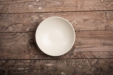 Empty dish on wood background. Top view.