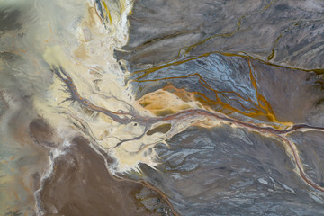 Top down view on abstract patterns and shapes of mineral waste rivers from power plant.