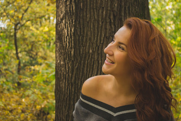Naklejka premium Redhead woman in the park at autumn.