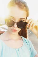 Naklejka premium Beautiful young girl with sunglasses on sunny street
