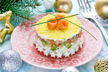 Christmas layered salad with salmon, avocado, rice and cream cheese salad on holiday table
