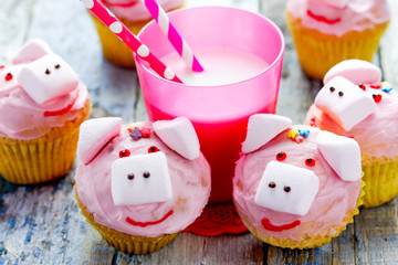 Pink pig cupcakes - homemade cupcakes decorated with cream cheese frosting and marshmallow shaped funny piggies, christmas and new year 2019 sweet treat for kids