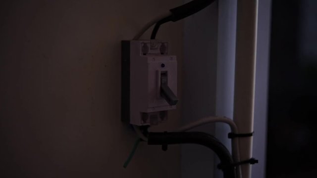 finger is about to switch off  on an RCD circuit breaker board
