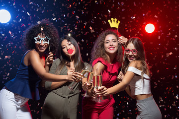 Happy women celebrating New Year at nightclub - obrazy, fototapety, plakaty