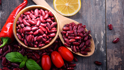Composition with bowl of kidney bean on wooden table