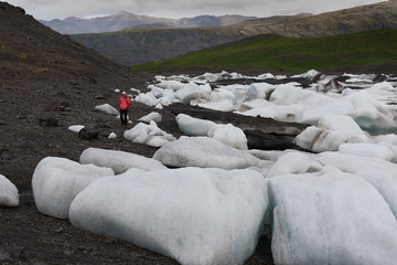 Woman is walking near the glacier in Iceland