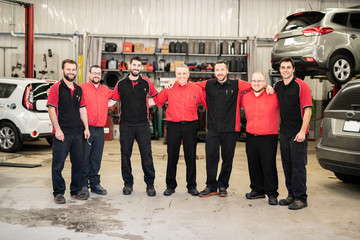 Portrait of auto shop mechanics group together employee