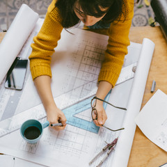 Top view of architect woman working on architectural project for interior design.