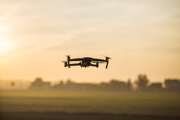 Drone like Mavic 2 Pro flying during sunset.