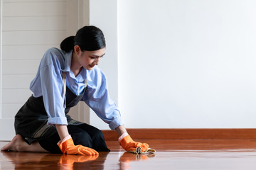 Woman cleaning house with old cloth.