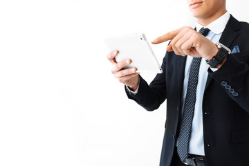 Business man, in a suit and glasses, working on a digital tablet, standing on a white background