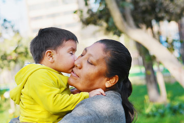 Fototapeta premium Tender portrait of little son kissing hismy.