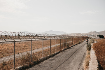 Runway behind fence with barbed wire