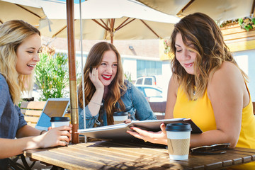 A group of young millennial business women have a meeting at a cafe