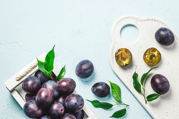 Ripe plums in a box. Top view, space for text.