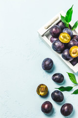 Ripe plums in a box. Top view, space for text.