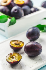 Ripe plums in a box. Selective focus, space for text.