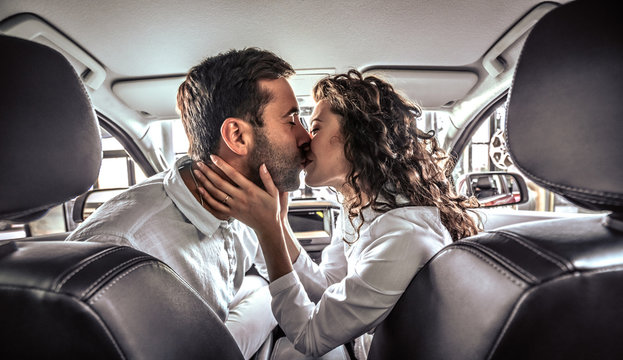 Happy Beautiful Couple In Love Kissing In A New Car