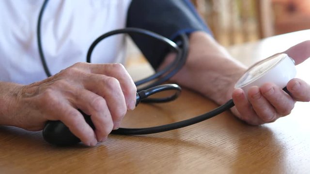 Closeup Of Senior Woman Hands With Tonometer Checking Blood Pressure Level