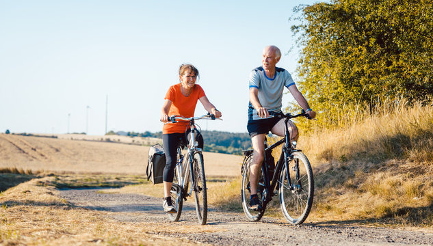 Senioren Paar f&auml;hrt Fahrrad f&uuml;r bessere Fitness als Sport 