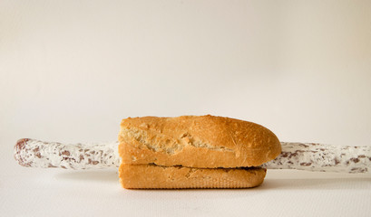 Longaniza de cerdo que sobresale por ambos lados en un pan demasiado pequeño.