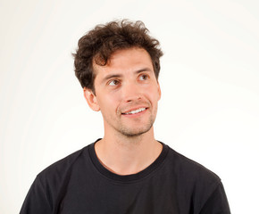 Obraz premium Miły młody człowiek marzy i uśmiecha się