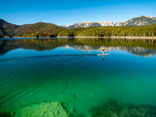 Image of stand up paddling on a beautiful mountain lake in autumn