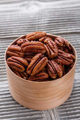 delicious pecan nuts on a rustic wooden background