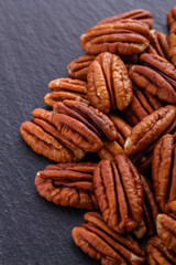 delicious pecan nuts on a dark stone background