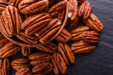 delicious pecan nuts on a dark stone background