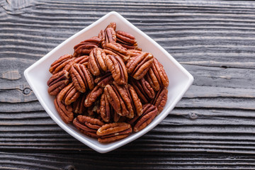 delicious pecan nuts on a rustic wooden background