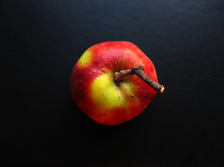 Red-yellow apple on a black background