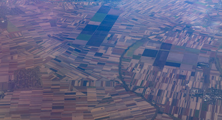 Agricultural fields from above. Aerial view out of an airplane window.