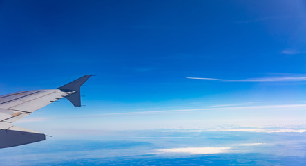 Naklejka na ściany i meble Blue sky with clouds. View out of an airplane window.